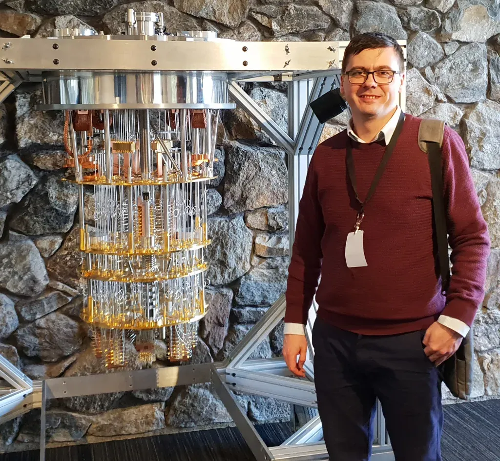 Łukasz Herok next to the IBM quantum computer